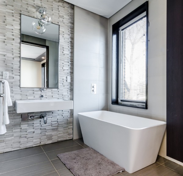 modern bathroom with accent wall tile and big soaking tub